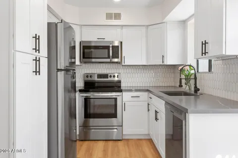a kitchen with stainless steel appliances granite countertop a sink stove and refrigerator