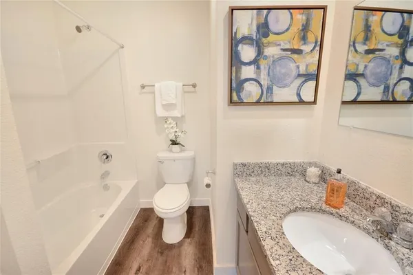 a bathroom with a granite countertop toilet sink and mirror