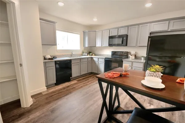 a kitchen with stainless steel appliances kitchen island granite countertop a stove a sink a dining table and chairs
