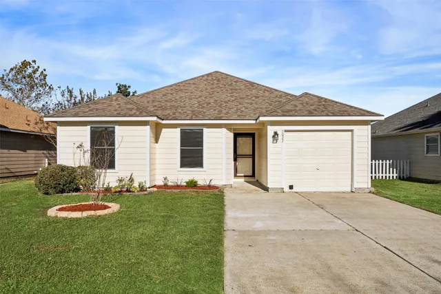 a front view of a house with a garden and yard
