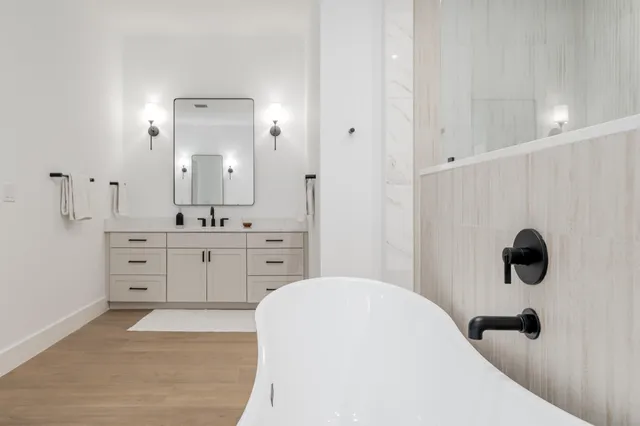 a bathroom with a tub sink and mirror
