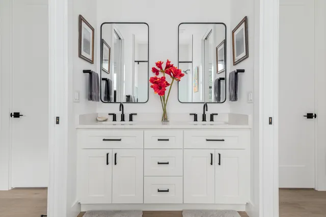 a bathroom with double vanity sink a mirror and shower