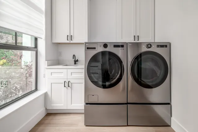 a utility room with sink dryer and washer