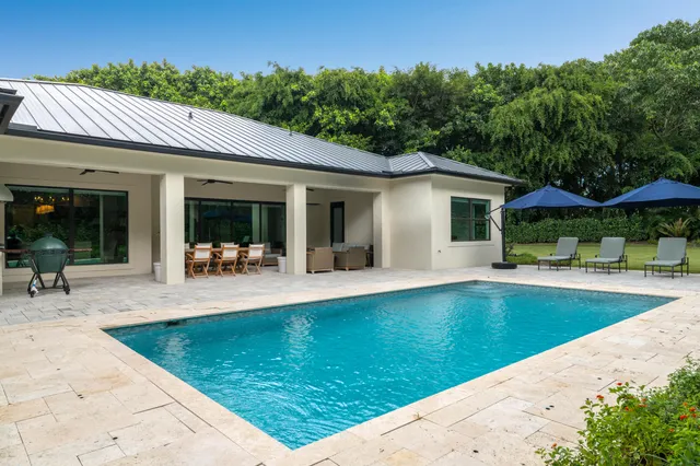 a view of a house with a swimming pool and sitting area