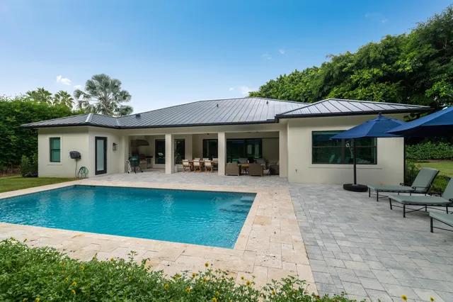 a view of a backyard with couches and swimming pool