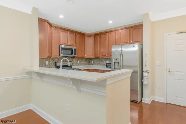 a kitchen with stainless steel appliances granite countertop a refrigerator stove top oven a sink and dishwasher