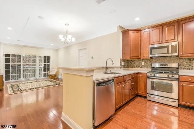 a kitchen with stainless steel appliances granite countertop a stove a sink and a microwave