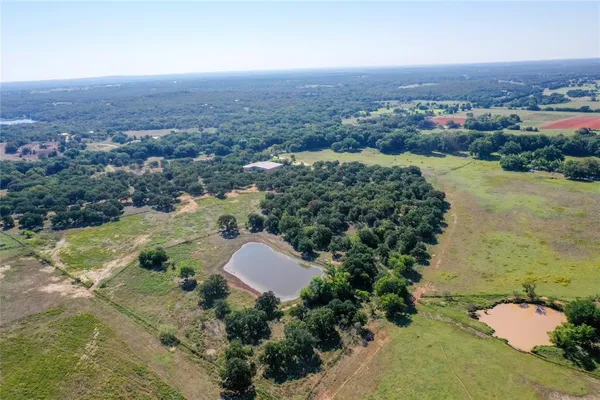 an aerial view of a house with a yard and lake view