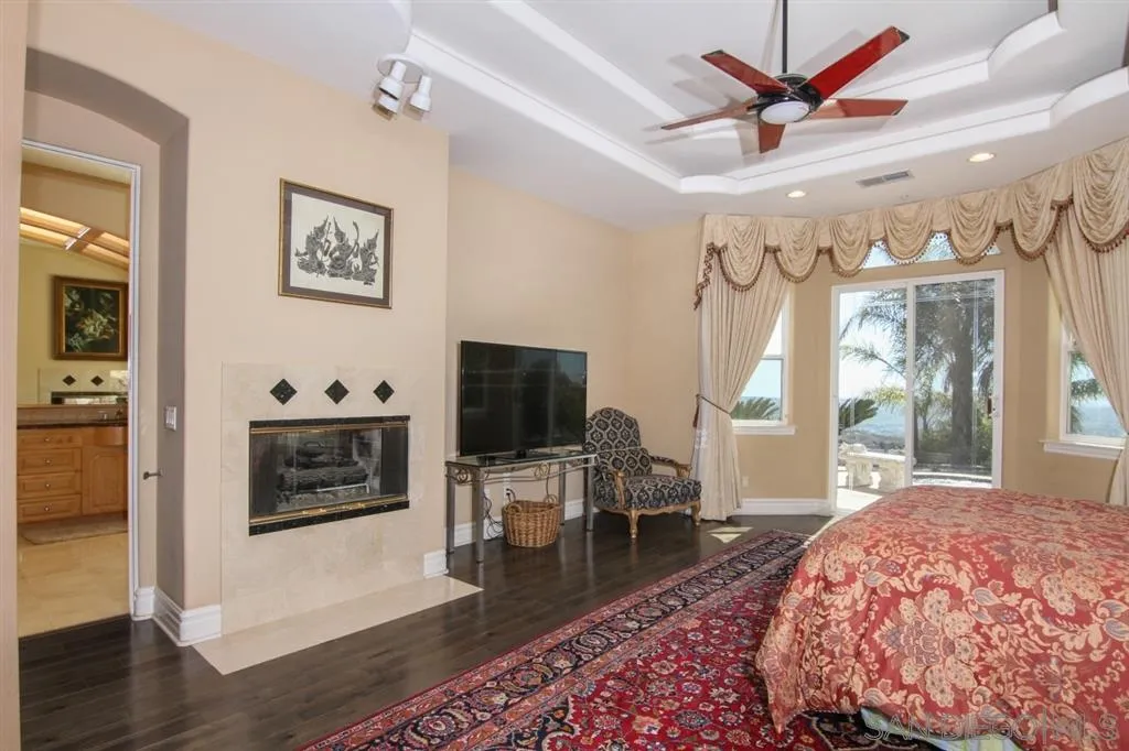 16040 Eucalyptus Heights Road Poway, CA 92064 - Photo 11 of 25 a living room with furniture a flat screen tv and a fireplace
