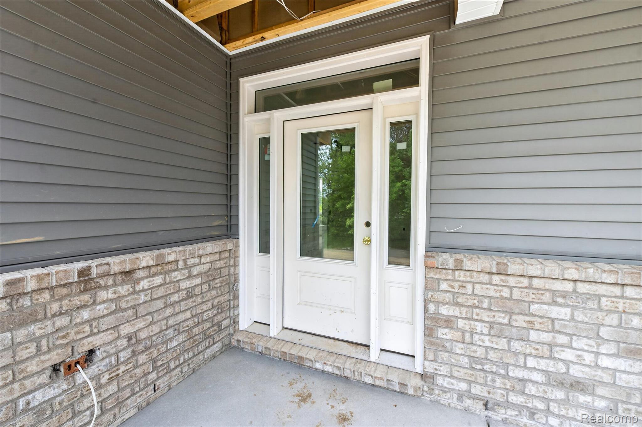 3297 Oak Grove Road Howell, MI 48855 - Photo 3 of 40 Welcoming covered front porch entry with transom window and brick accents.