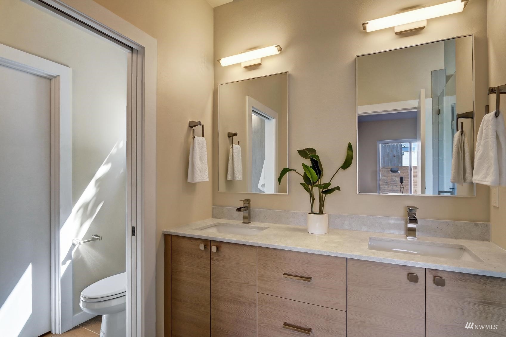 6525 Chapin Place North Seattle, WA 98103 - Photo 20 of 35 a bathroom with a double vanity sink toilet and a mirror