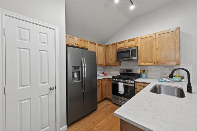 a kitchen with stainless steel appliances a sink cabinets and wooden floor
