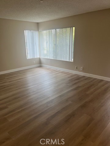 48 Clearbrook, Unit 56 Irvine, CA 92614 - Photo 4 of 6 an empty room with wooden floor and windows
