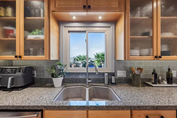 a kitchen with granite countertop a sink and a stove
