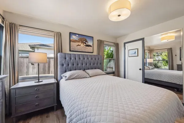 a bedroom with a bed and a large mirror on the dresser