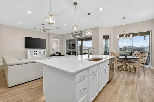a large white kitchen with a large island in the center and white cabinets