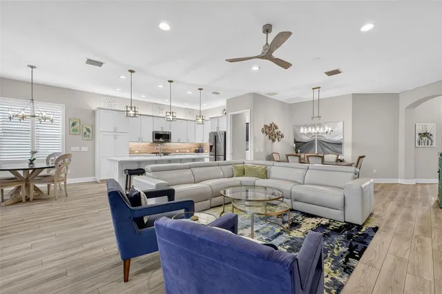 a living room with furniture kitchen view and a dining table