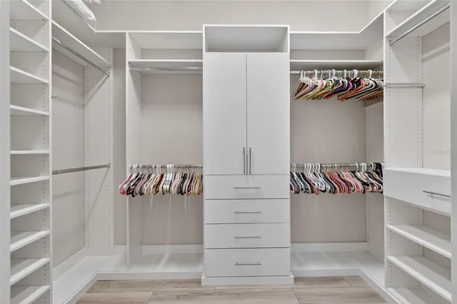 a view of walk in closet with clothes and shoes