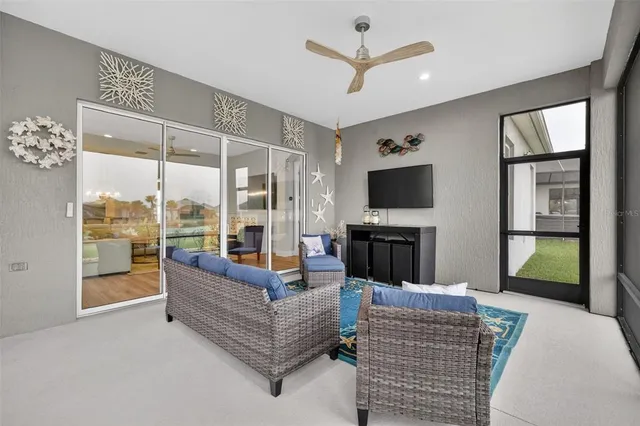a living room with furniture a flat screen tv and a floor to ceiling window