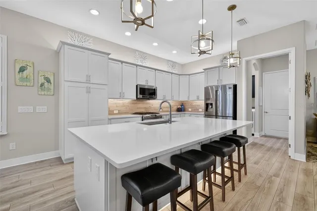 a kitchen with kitchen island a stove a table and chairs in it