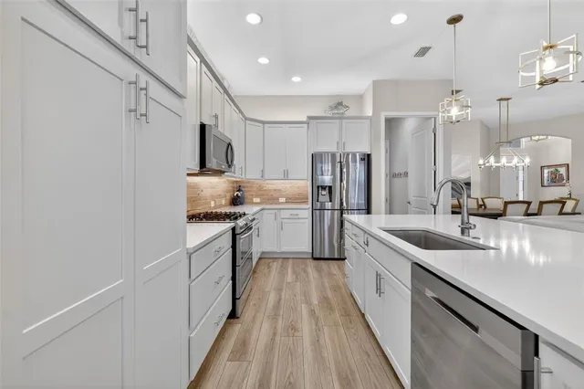 a kitchen with stainless steel appliances granite countertop a sink and a refrigerator