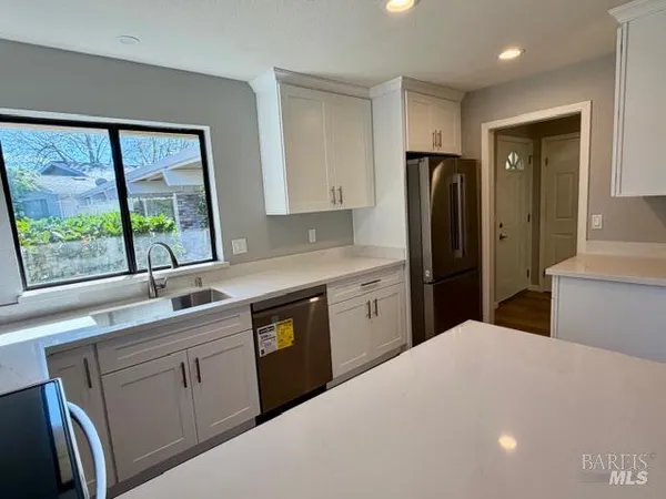 a kitchen with stainless steel appliances a refrigerator sink and wooden cabinets