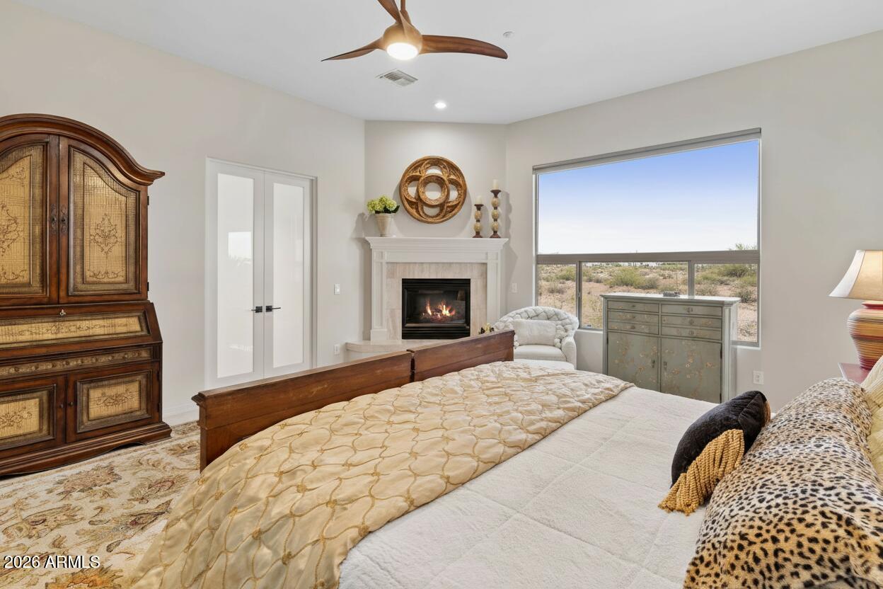 15730 East Eagle Crest Road Fountain Hills, AZ 85268 - Photo 30 of 77 a bedroom with a bed and a fireplace with a chandelier