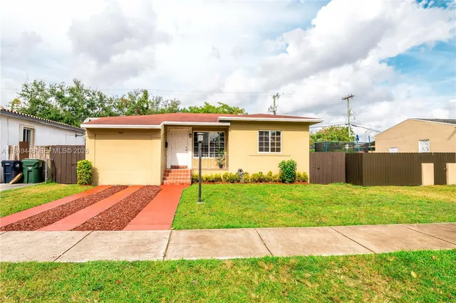 a front view of a house with a garden and yard
