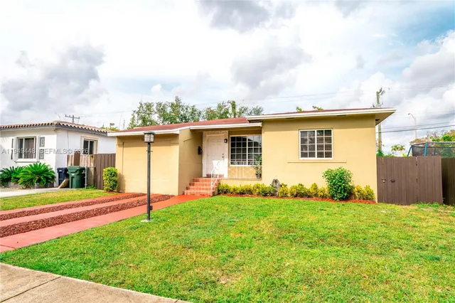 a view of a house with a yard and plants