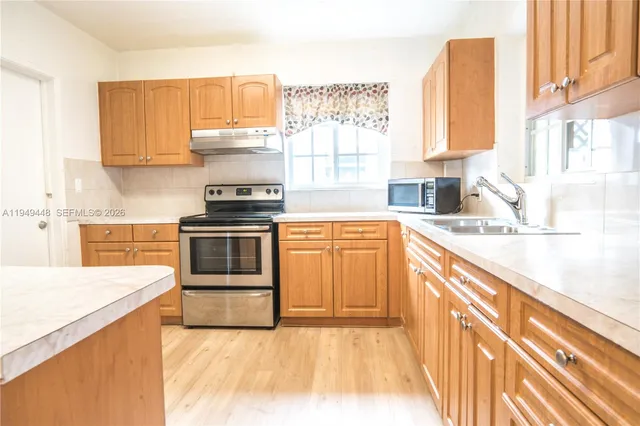 a kitchen with a sink a stove and cabinets