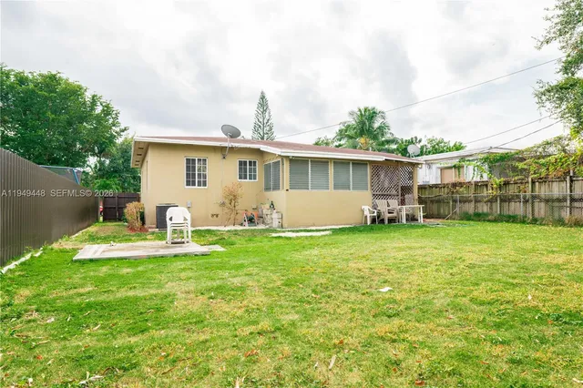 a backyard of a house with table and chairs