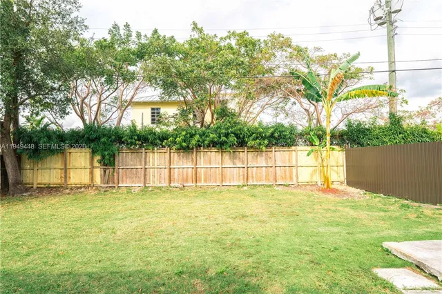 a view of a yard with wooden fence