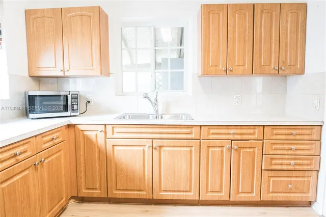a kitchen with stainless steel appliances granite countertop white cabinets and a counter space