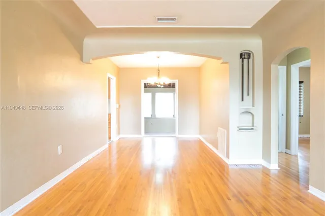a view of a hallway with wooden floor and a bathroom