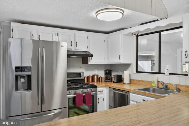 a kitchen with a refrigerator sink and cabinets