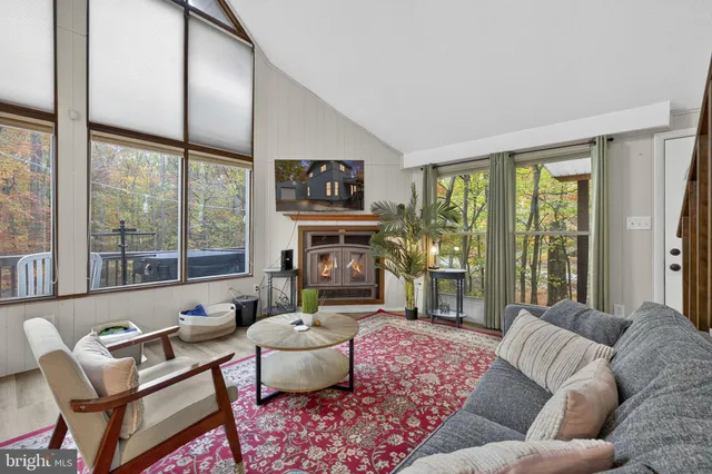 a living room with furniture large window and flat screen tv