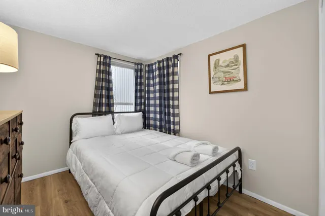 a view of a hallway with wooden floor and furniture