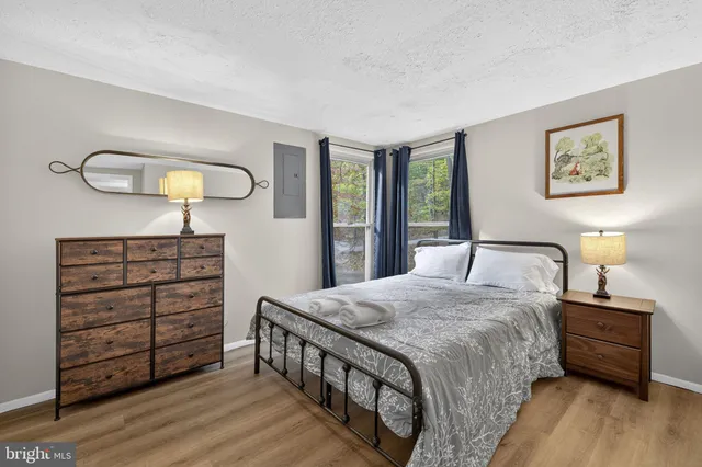 a view of a hallway with wooden floor and a living room