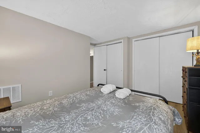 a view of a bedroom with wooden floor and cabinet