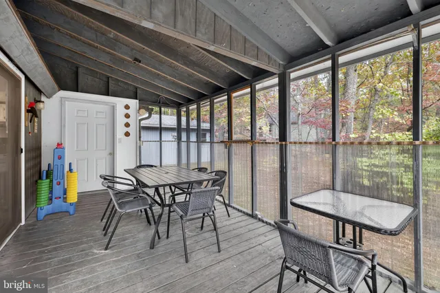 a view of a balcony with two chairs and a large tree