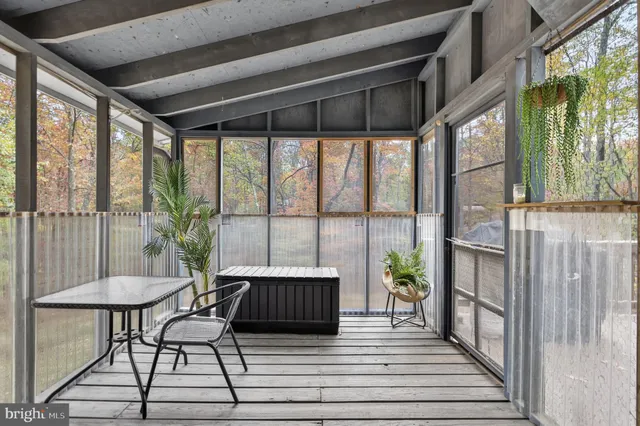 a view of a house with a wooden deck and furniture