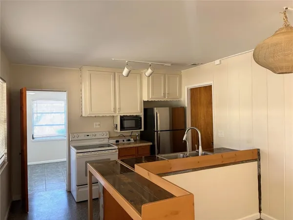 a kitchen with stainless steel appliances a refrigerator a stove a sink and a refrigerator with wooden floor