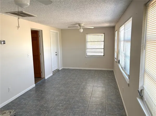 an empty room with a window and a fan
