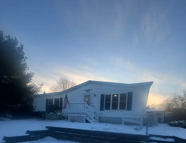 a front view of a house with plants and trees