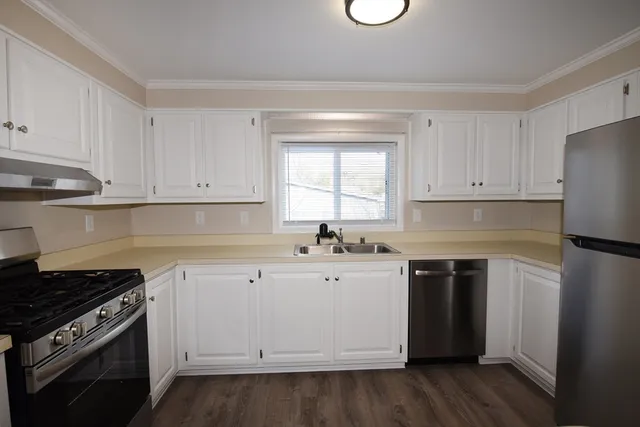 a kitchen with white cabinets and appliances