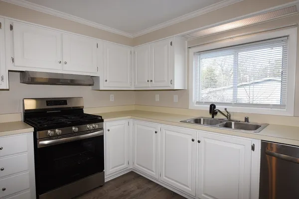a kitchen with white cabinets and appliances
