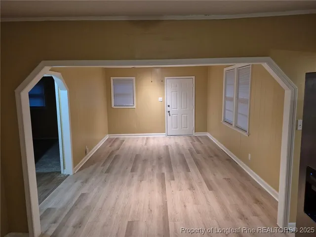a view of empty room with wooden floor