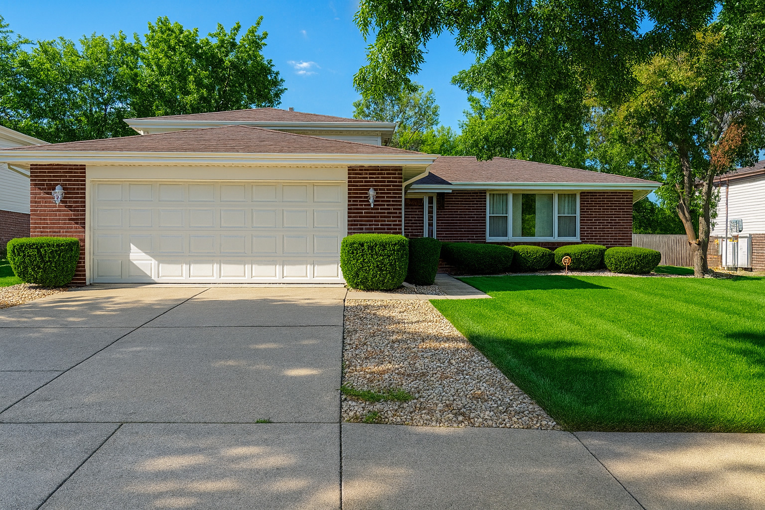 a front view of a house with a yard and trees