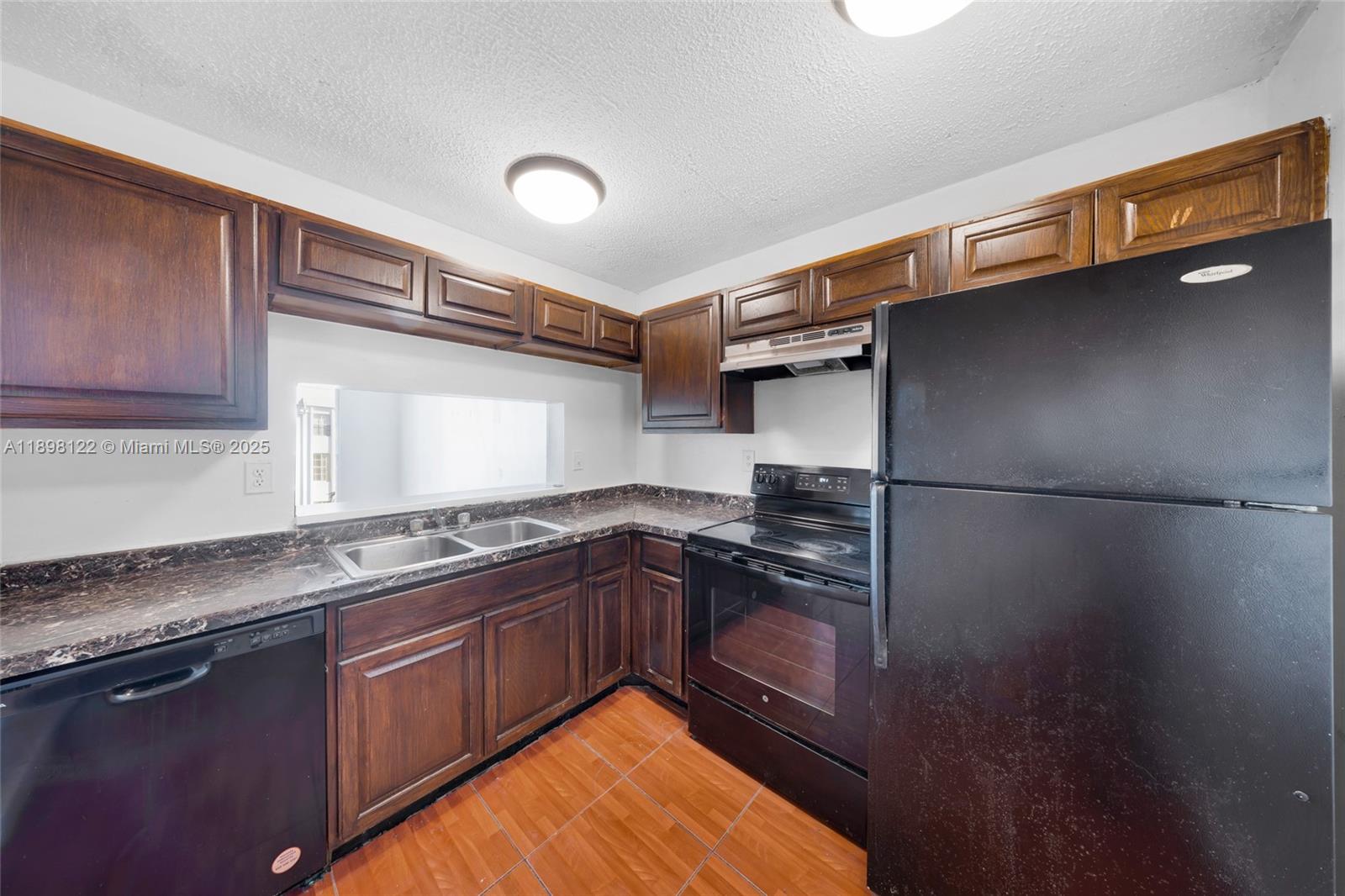 492 Northwest 165th Street, Unit C512 Miami, FL 33169 - Photo 11 of 27 a kitchen with stainless steel appliances granite countertop a sink stove and refrigerator