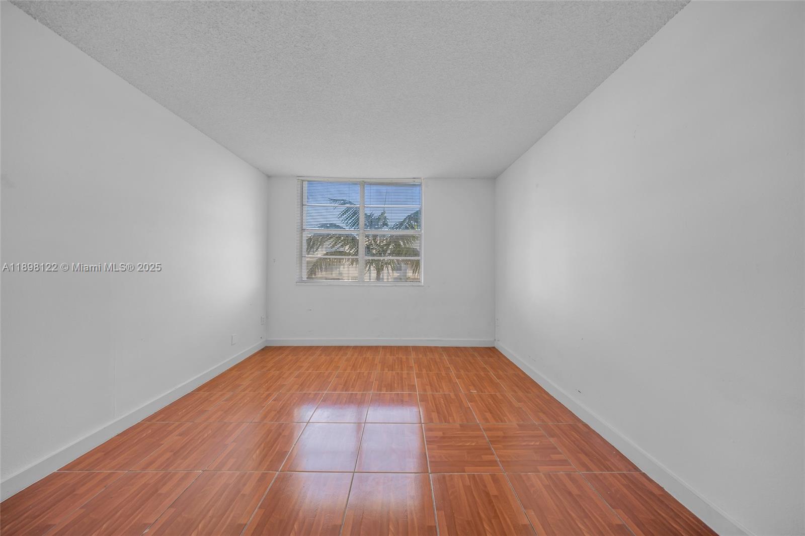 492 Northwest 165th Street, Unit C512 Miami, FL 33169 - Photo 12 of 27 an empty room with wooden floor and windows